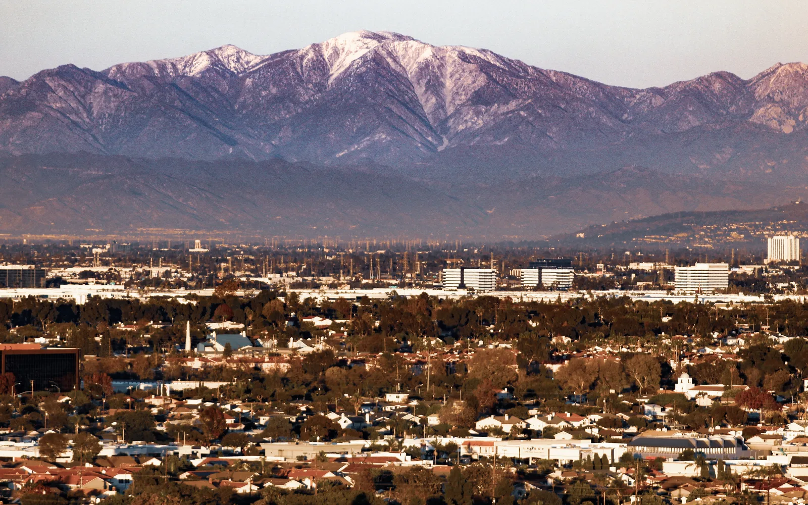 View of Mount Baldy and the San Gabriel Mountains looming over the Los Angeles Basin with clouds in the sky